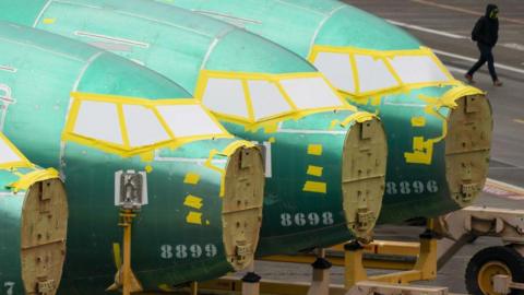 A worker walks past Boeing 737 fuselages outside the Boeing Co. manufacturing facility in Renton, Washington, US, on Monday, Feb. 5, 2024.