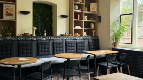 New cafe layout with clean seating and tables - and ornaments in wall nooks