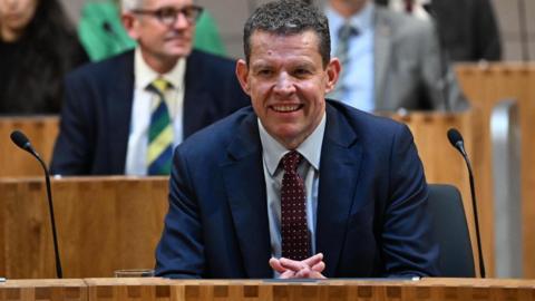 Rhan ap Iorwerth smiling in the Senedd, 