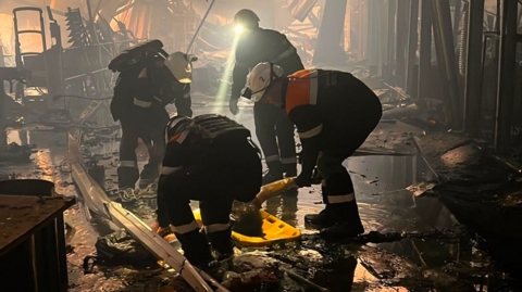 Ukrainian emergerncies workers search through the rubble at a shopping centre in Kryvyi Rih following a deadly Russian drone attack. Photo: 22 August 2026