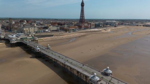 An aerial photograph taken with a drone shows people on the North Pier in Blackpool.