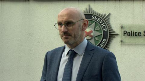 Ch Insp Anthony Kelly in navy suit and patterned white shirt