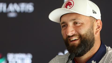 Jon Rahm smiling while answering questions from the media in Dubai