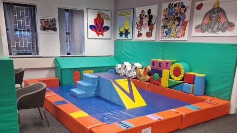 A children's soft play area, with paintings of cartoon characters above.