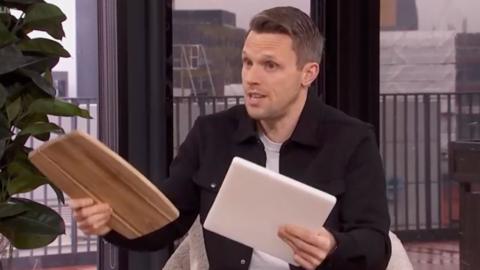 Greg Foot holding a wooden and plastic chopping board