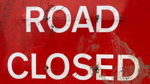 A red 'road closed' road sign.