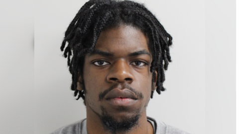 Renaldo Roberts, who has cornrows and is looking directly into the camera. He is standing in front of a white background.