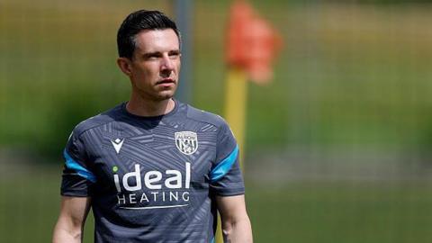 Andrew Nestor in his grey West Bromwich Albion training top watches training during the club's pre-season tour of Austria