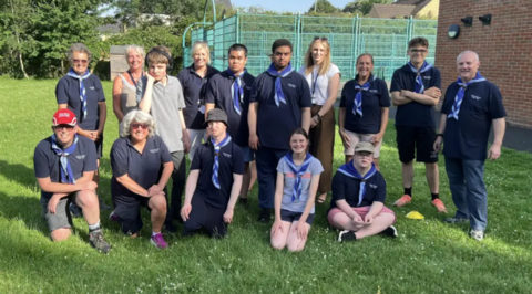 A group of young people in scout uniform.