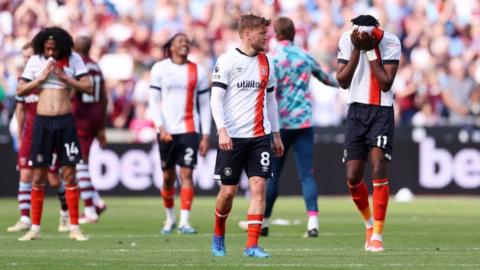 Luton players looks upset at the final whistle after loss at West Ham which leaves them on brink of relegation