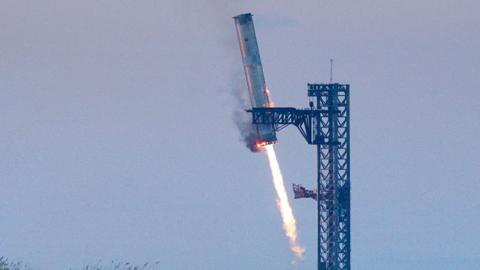 SpaceX's Super Heavy booster fires out of its exhaust at the bottom of the rocket itself while it lands into the rocket launcher holder that it fired out of, during SpaceX Starship's fifth flight test, in Boca Chica, Texas, U.S., October 13, 2024