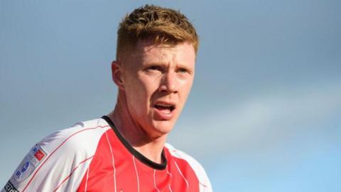 Sam Clucas in his red and white Lincoln City shirt during a match