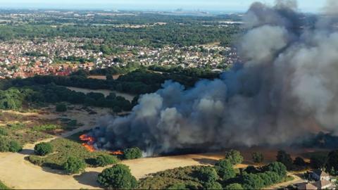 Aerial image of a large wildfire in an area of heathland on Rushmore Heath, Ipswich, Suffolk from August 2022
