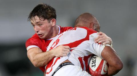 Dan Edwards tackles a Japan attacker