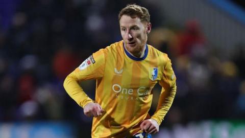 Mansfield Town midfielder Stephen Quinn passing the ball.