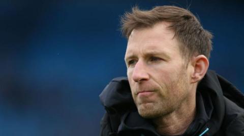 Carlisle head coach Mike Williamson watching the match against Accrington 