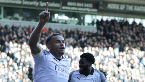 Carlton Morris raises his right hand in celebration after scoring for Derby against QPR