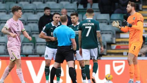 Plymouth Argyle's players speak with the referee after the awarding of Bradford City's penalty at Home Park