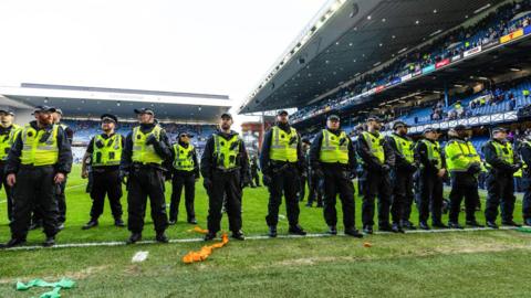 A line of police oficers on the pitch at Ibrox.