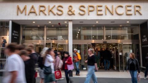A M&S shopfront is seen in Bath in 2024, with people walking past on the high street.