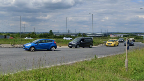 Cars driving around a large roundabout.