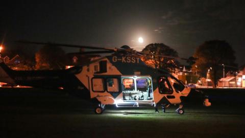 An air ambulance that has landed on a patch of a grass in a suburban street in Worthing.