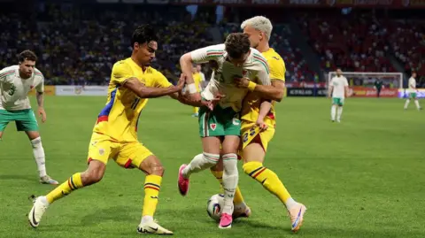 Wales and Romania battle for the ball