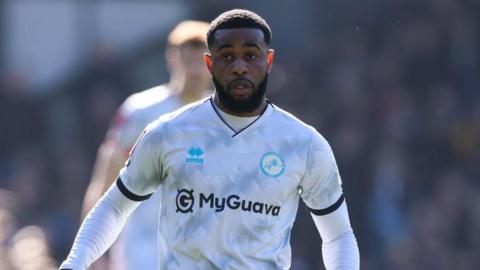 Japhet Tanganga, wearing Millwall's white and grey patterned away strip