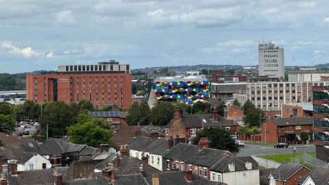 An aerial view of Hanley. Prominent landmarks in the shot include the Hilton hotel, the Smithfield development and the former BT building. In the foreground is housing.