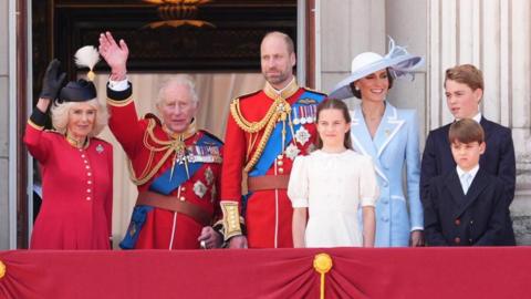 Queen Camilla, King Charles, the Prince of Wales, Princess Charlotte, the Princess of Wales, Prince George and Prince Louis stand on the balcony at Buckingham Palace.