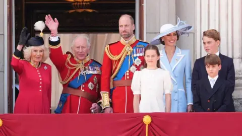 Queen Camilla, King Charles, the Prince of Wales, Princess Charlotte, the Princess of Wales, Prince George and Prince Louis stand on the balcony at Buckingham Palace.