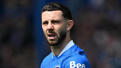 Conor Chaplin in a blue Portsmouth shirt looks ahead with mouth open