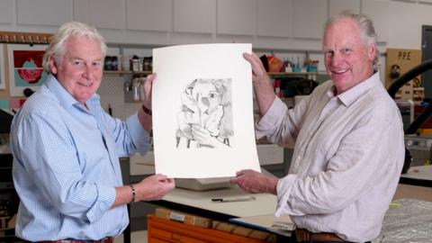 Two men hold up a fine art drawing suspected to be drawn by Lucien Freud
