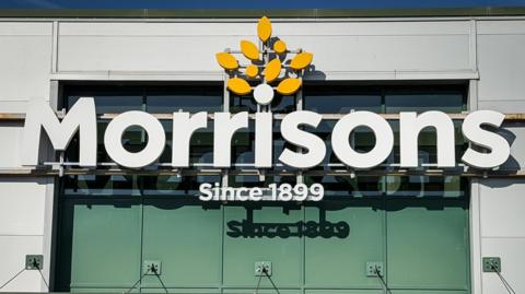 The Morrisons supermarket logo, emblazoned in large letters on the front of a building.
