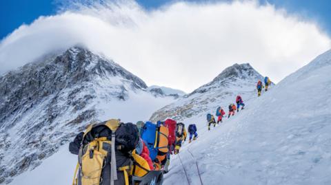 A line of people climbing up Mount Everest.