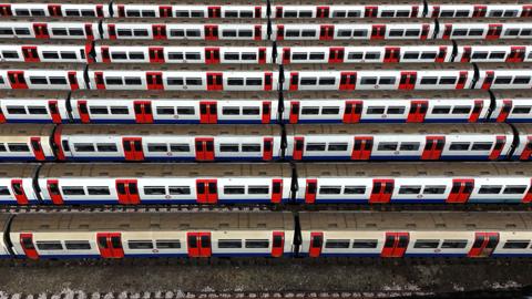 Line of Tube trains parked at depot.