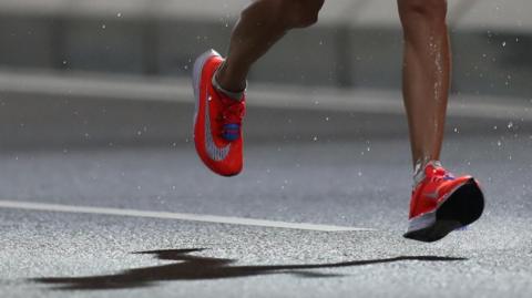 Runner's red shoes and shadow