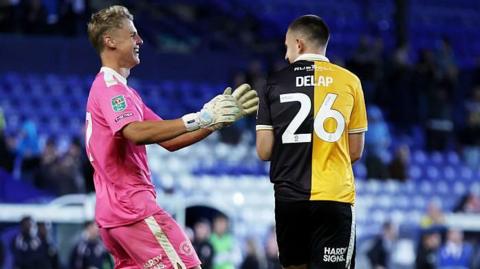 Burton's Fin Delap celebrates with keeper Kamil Dudek after Burton's win on penalties