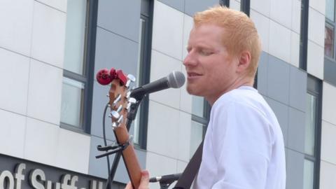 Ed Sheeran singing.