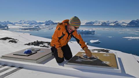 woman cleaning sky camera in Antarctica