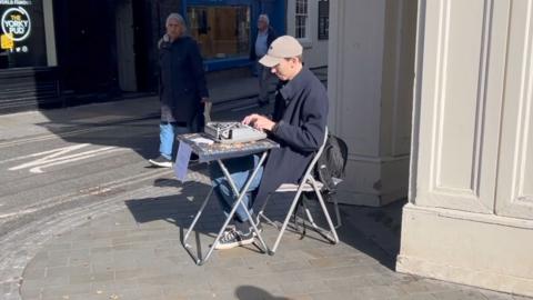 A man sitting by a typewriter in York city centre