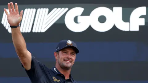 Bryson DeChambeau waves to fans in front of a LIV Golf logo during day four of LIV Golf New York at Trump National Golf Club in August 2026