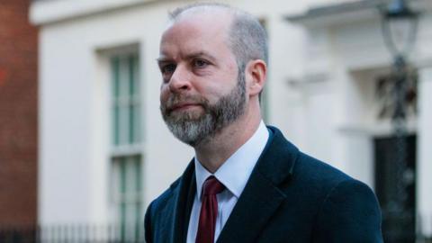 Jonathan Reynolds, business secretary for the UK government, wearing a dark coat and a dark red tie.