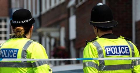 Two backs of two police officers. The picture is generic and not of the scene.