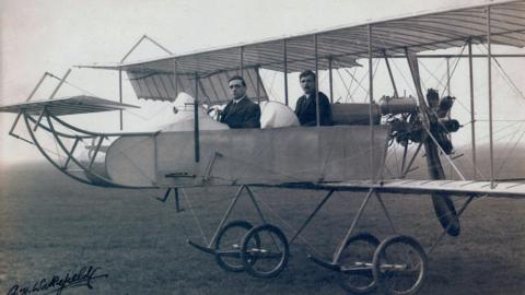 Black and white image of Oswald and Eustace Short sat in a S38 R7 Engined Pusher Biplane.