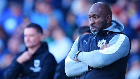 Darren Moore stand with his arms crossed watching on from the touchline during a game