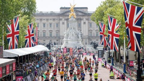 Buckingham Palace in the background with marathon runners in the foreground