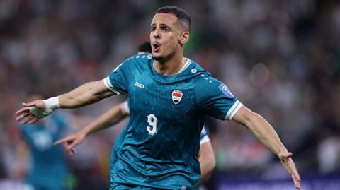 Ali Al-Hamadi in a green Iraq kit celebrating his goal against Bolivia