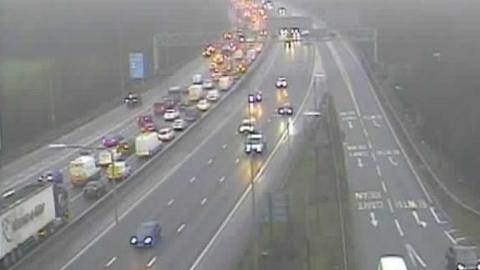 Traffic queuing on one side of a three lane carriageway. The other side is has free-flowing traffic.