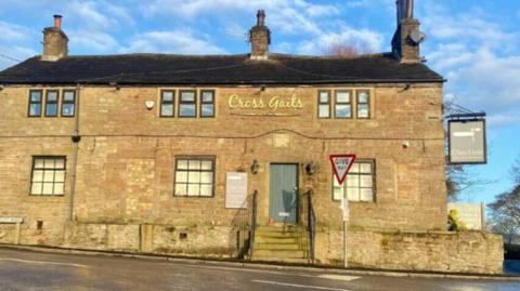 The yellow bricked-front of the Cross Gaits pub, which is on a main road.